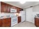 Well-lit kitchen with white appliances, dark wood cabinets, and granite countertops at 5300 S Atlantic Ave # 5-502, New Smyrna Beach, FL 32169