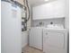 A laundry room featuring a washer, dryer, water heater, and upper cabinets at 5300 S Atlantic Ave # 5-502, New Smyrna Beach, FL 32169