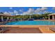 Large community pool and waterfall feature surrounded by lounge chairs and tropical foliage on a sunny day at 5300 S Atlantic Ave # 5-502, New Smyrna Beach, FL 32169