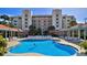 Luxury resort-style pool and lounging area surrounded by palm trees, with ample seating and a stunning building backdrop at 5300 S Atlantic Ave # 5-502, New Smyrna Beach, FL 32169