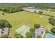 Aerial view showcasing sports courts, open field, shopping center and surrounding landscape at 5849 Ansley Way, Mount Dora, FL 32757