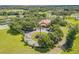 Aerial view of a clubhouse surrounded by trees, a parking lot, and landscaping at 5849 Ansley Way, Mount Dora, FL 32757