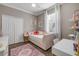 Charming bedroom with hardwood floors, a pink sofa-style bed, and a bright, airy window at 5849 Ansley Way, Mount Dora, FL 32757