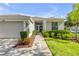 Welcoming home entrance with a charming blue door, manicured landscaping, and a well-maintained exterior at 5849 Ansley Way, Mount Dora, FL 32757