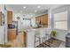 Bright kitchen features wooden cabinetry, a breakfast bar, and views into the living area at 5849 Ansley Way, Mount Dora, FL 32757
