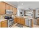 Bright kitchen area with stainless steel appliances and a view to the outdoor pool at 5849 Ansley Way, Mount Dora, FL 32757
