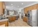 Open kitchen with stainless steel appliances, tile flooring, and a view into the living room at 5849 Ansley Way, Mount Dora, FL 32757