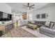 Open living room with hardwood floors and open access to a kitchen with breakfast bar at 5849 Ansley Way, Mount Dora, FL 32757