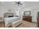 Serene main bedroom boasts tray ceilings, a large window, and a well-appointed dresser at 5849 Ansley Way, Mount Dora, FL 32757