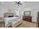 Relaxing bedroom suite with tray ceilings, a ceiling fan, and wood-look flooring at 5849 Ansley Way, Mount Dora, FL 32757