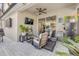 Covered patio with ceiling fan, comfortable seating, mounted TV, and potted plants at 5849 Ansley Way, Mount Dora, FL 32757