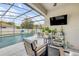 Screened-in pool area featuring comfortable lounge seating, a TV, and several plants at 5849 Ansley Way, Mount Dora, FL 32757