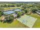Aerial view of community tennis and basketball courts next to a pond providing recreational opportunities at 5849 Ansley Way, Mount Dora, FL 32757
