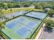 Aerial view of community tennis courts and pond providing outdoor recreational opportunities and scenic views at 5849 Ansley Way, Mount Dora, FL 32757