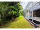 Lush backyard with a screened pool enclosure, offering privacy and a seamless transition between indoor and outdoor living at 6065 Spruce Point Cir, Port Orange, FL 32128