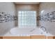 Luxurious bathroom with garden tub, decorative tile accents, and glass block window at 6065 Spruce Point Cir, Port Orange, FL 32128