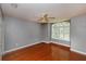 Empty bedroom showcasing hardwood floors, a large window, and a ceiling fan for a bright and airy feel at 6065 Spruce Point Cir, Port Orange, FL 32128