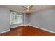 Spacious empty bedroom with hardwood floors, a ceiling fan, and plantation shutters for privacy and light control at 6065 Spruce Point Cir, Port Orange, FL 32128