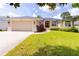 Charming single-story home with a well-manicured lawn, inviting curb appeal, and attached two-car garage at 6065 Spruce Point Cir, Port Orange, FL 32128