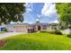 Charming single-story home with a manicured lawn, mature trees, and inviting curb appeal at 6065 Spruce Point Cir, Port Orange, FL 32128