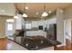 Well-lit kitchen boasting white cabinets, stainless steel appliances, and a large granite island at 6065 Spruce Point Cir, Port Orange, FL 32128