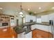 Inviting open concept featuring a kitchen with island, stainless appliances, and stone fireplace at 6065 Spruce Point Cir, Port Orange, FL 32128