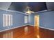 Main bedroom with a tray ceiling, hardwood floors, large windows, and a doorway to an adjoining room at 6065 Spruce Point Cir, Port Orange, FL 32128