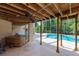Spacious covered patio featuring ceiling fans, adjacent to a relaxing hot tub and a view of the pool, ideal for outdoor living at 6065 Spruce Point Cir, Port Orange, FL 32128