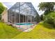 Exterior view highlighting the screened-in pool, the home's architecture, and the integration with the surrounding landscape at 6065 Spruce Point Cir, Port Orange, FL 32128