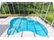 Screened-in pool with clear blue water and ample space for lounging, surrounded by lush greenery at 6065 Spruce Point Cir, Port Orange, FL 32128