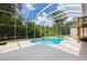 Screened-in pool with lush landscaping and outdoor area, offering a secluded and relaxing backyard experience at 6065 Spruce Point Cir, Port Orange, FL 32128
