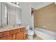 Clean bathroom with tub, toilet and wood vanity at 5244 Oakbourne Ave, Davenport, FL 33837