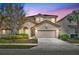 Two-story house with a beige exterior, two-car garage, and landscaping at 5244 Oakbourne Ave, Davenport, FL 33837