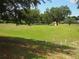 Lush backyard with mature trees and manicured green space offers a tranquil retreat at 3918 Doune Way, Clermont, FL 34711
