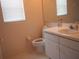 Cozy bathroom featuring a toilet, sink, vanity, and a mirrored wall cabinet at 3918 Doune Way, Clermont, FL 34711
