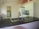 Bright kitchen with granite countertops, stainless sink, white appliances, and easy access to the laundry room at 3918 Doune Way, Clermont, FL 34711