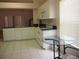 Bright kitchen featuring stainless sink, white cabinetry, and modern appliances, adjacent to an eat-in area with natural light at 3918 Doune Way, Clermont, FL 34711