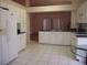 Open kitchen with tiled floor, white cabinetry, stainless sink, and modern appliances that flow into an adjacent living space at 3918 Doune Way, Clermont, FL 34711