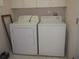 Bright laundry area with a white dryer and washing machine, with overhead storage cabinets at 3918 Doune Way, Clermont, FL 34711
