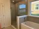 Modern bathroom showcasing a glass-enclosed shower, soaking tub, and neutral tiling at 515 Ingleside Ln, Haines City, FL 33844