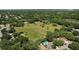 Picturesque aerial shot of expansive land with lush greenery, a pond, and a scattering of residential properties at 10290 Buck Rd, Orlando, FL 32817