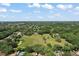 Wide aerial shot with expansive landscape of trees, lawns, houses and a pond, all under a blue sky at 10290 Buck Rd, Orlando, FL 32817