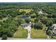 Expansive aerial view of a property featuring lush greenery, a private pond, and a long driveway at 10290 Buck Rd, Orlando, FL 32817