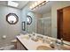 Bathroom with double sink vanity, octagonal window, and glass shower doors at 10290 Buck Rd, Orlando, FL 32817