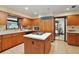 Functional kitchen with wooden cabinets, a center island, and adjacent dining area at 10290 Buck Rd, Orlando, FL 32817