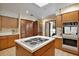 Well-lit kitchen with wooden cabinets, an island cooktop, and tile flooring at 10290 Buck Rd, Orlando, FL 32817