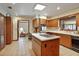 Spacious kitchen featuring wooden cabinets, an island cooktop, and an adjacent dining area at 10290 Buck Rd, Orlando, FL 32817
