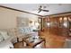 Cozy living room with hardwood floors, ceiling fan, and large decorative cabinet with glass doors at 10290 Buck Rd, Orlando, FL 32817