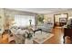 Bright living room featuring hardwood floors, floral sofas, and large windows with curtains at 10290 Buck Rd, Orlando, FL 32817