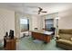 Office with large desk, ceiling fan, green carpet, and floral wallpaper at 10290 Buck Rd, Orlando, FL 32817